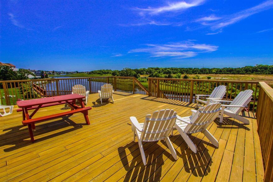 Deck with white chairs and red picnic table